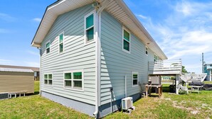 Uma casa de dois andares com telhado em gable, varanda frontal e uma pequena garagem anexa.