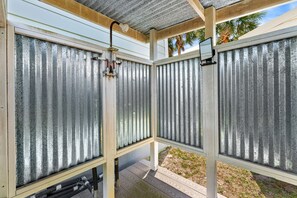 Ein überdachter Außenbereich mit Metallzaun und Holzterrasse.