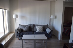 A modern living room with a grey sofa, a white coffee table, and two floor lamps. - At2202 in Denia With 2 Bedrooms and 2 Bathrooms (Denia)