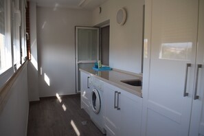 A compact laundry room with a washing machine, a sink, and a mirror. - At2202 in Denia With 2 Bedrooms and 2 Bathrooms (Denia)