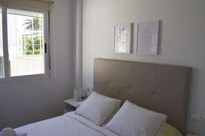 A bedroom with a bed, a bedside table, and two wall-mounted pictures. - Pb3201 in Denia With 3 Bedrooms and 2 Bathrooms (Denia)