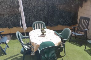 An outdoor patio with a round table, four chairs, and a potted plant. - Pb3201 in Denia With 3 Bedrooms and 2 Bathrooms (Denia)