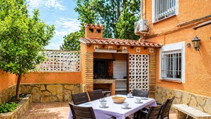 Un patio al aire libre con una mesa lista para comer, rodeado de muros de piedra y un suelo de baldosas.