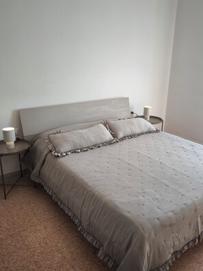 A bedroom with a bed, two bedside tables, and two wall-mounted lamps. - Vada Apartment - VadaLi (Vada)
