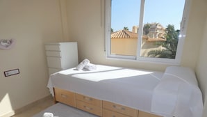 A bedroom with a bed, a window, a dresser, and a wall-mounted light switch. - Ap204 in Oliva With 2 Bedrooms and 1 Bathrooms (Oliva)