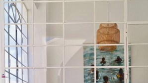 A room with a checkered floor, two wicker chairs, a small table, and a wall with a window displaying a painting of people in water. - Casa Estrela, a mansion in the heart of Olhão, (Olhão)