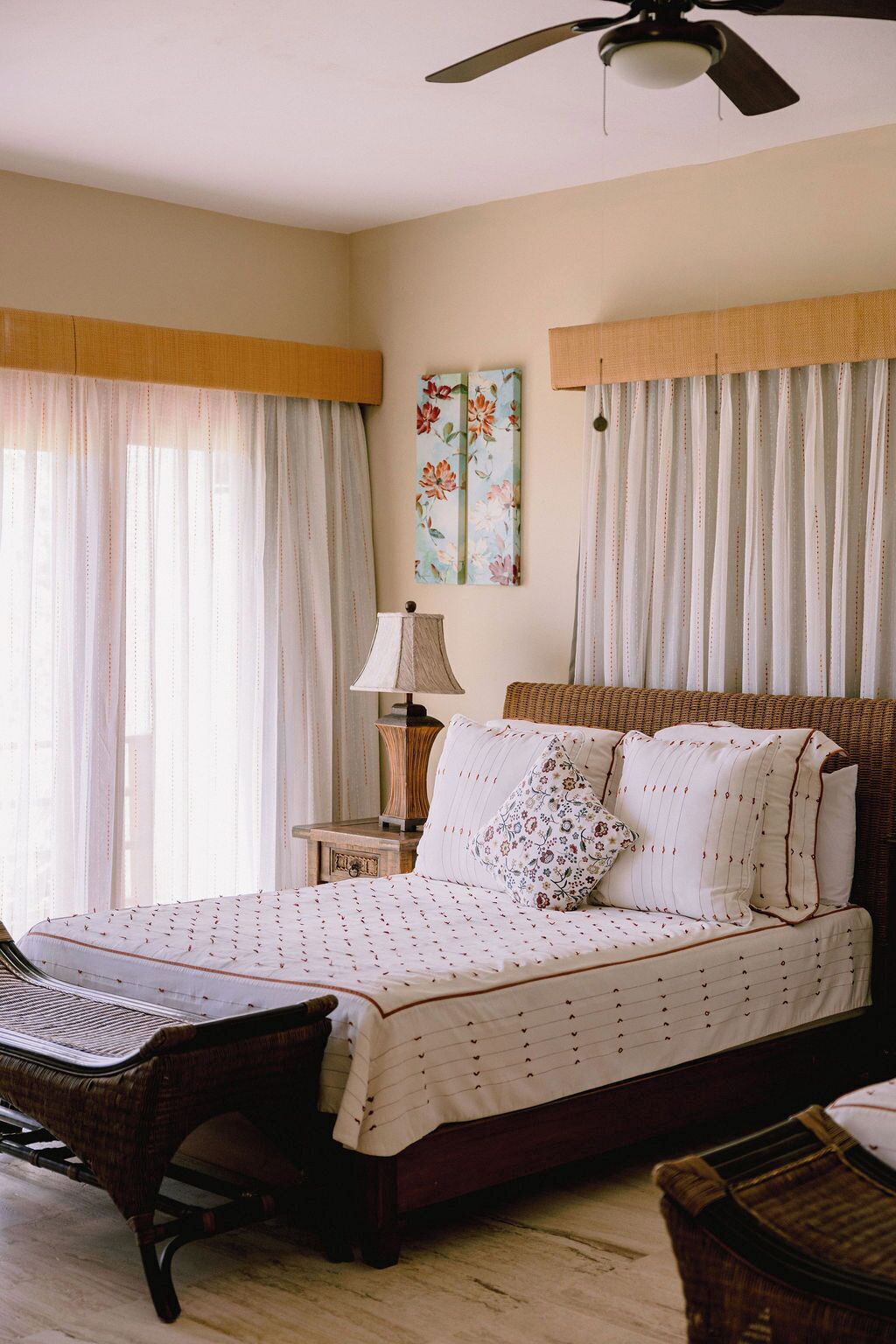 A bedroom with a bed, a nightstand, a lamp, and a ceiling fan.