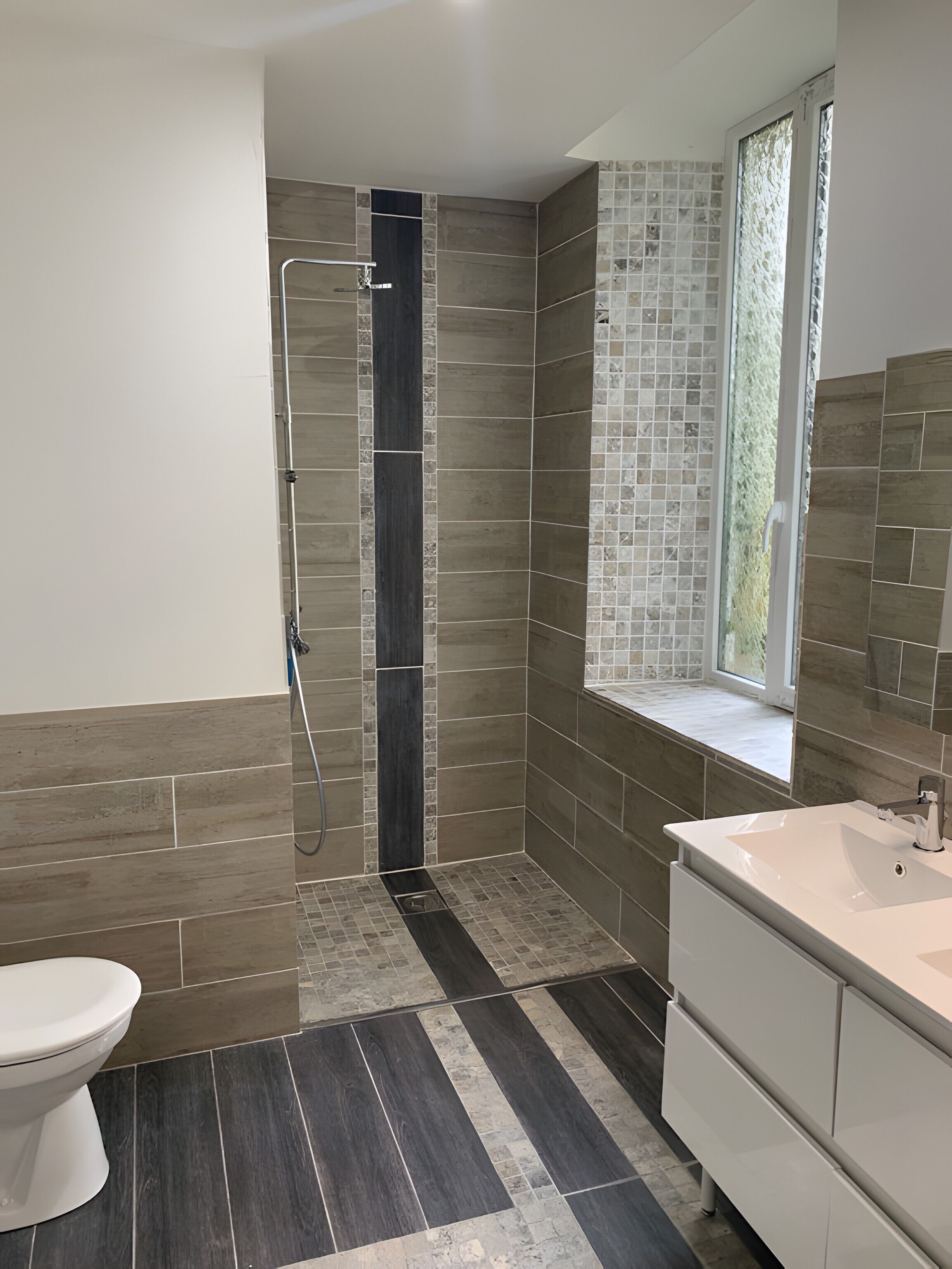 A modern bathroom with a shower, toilet, and vanity.