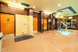Rebedor d'hotel amb panells de fusta, zona de piscina i diverses portes, incloses algunes accessibles per a persones amb mobilitat reduïda.