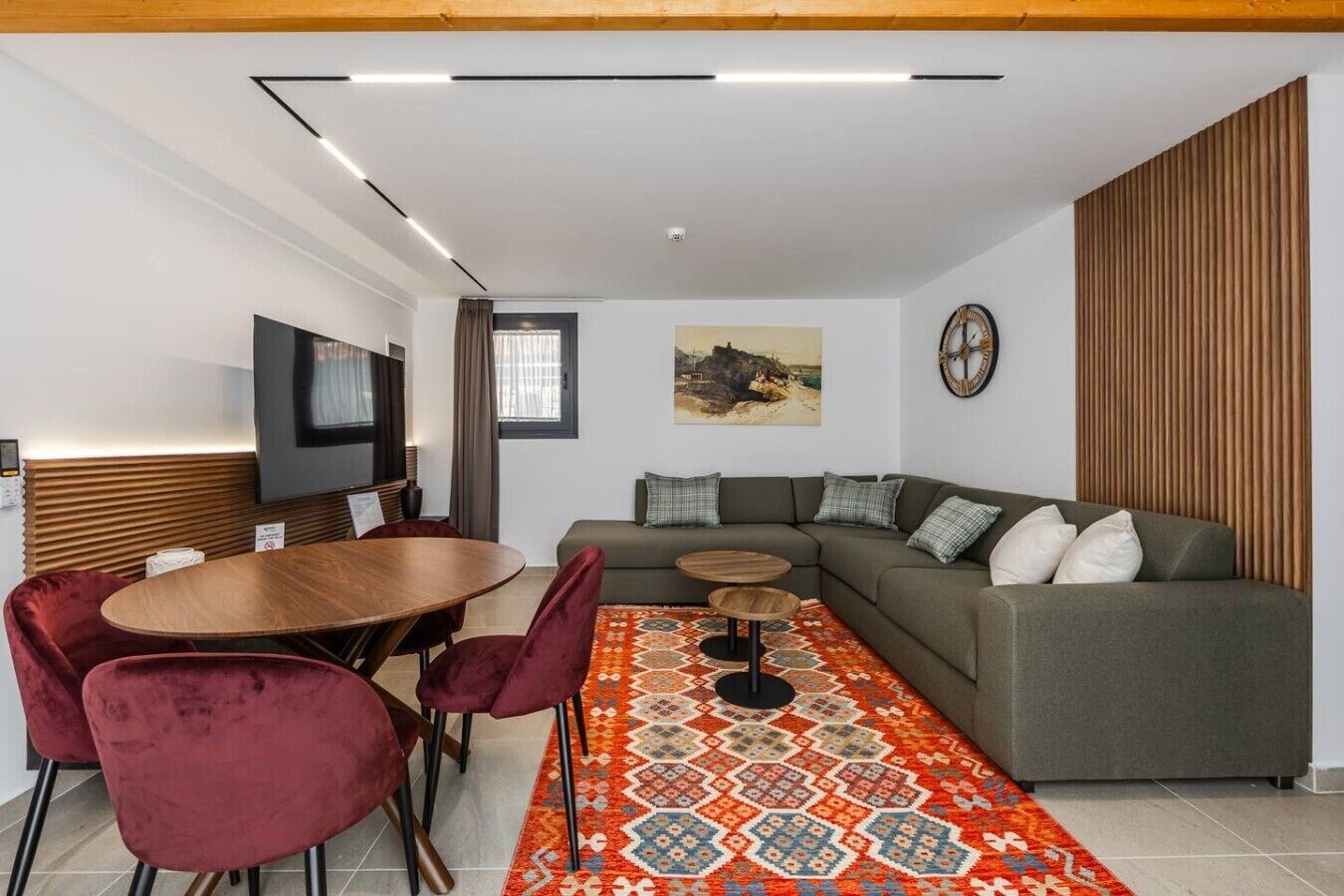 Uma sala de estar moderna com um sofá, uma mesa de jantar e uma televisão.