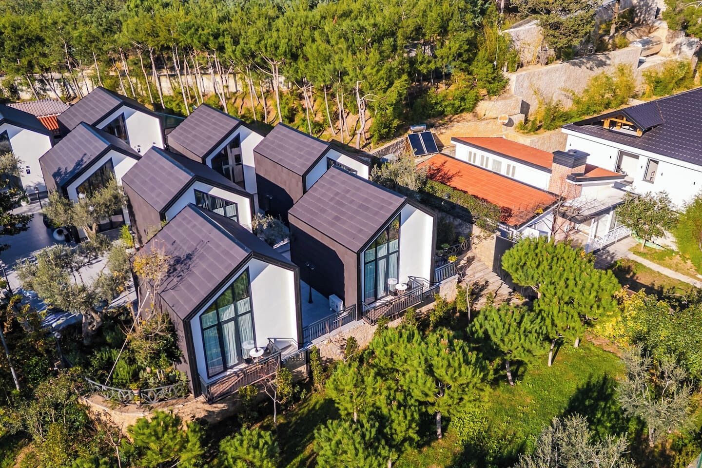 Et moderne boligområde med flere huse, store vinduer og flade tage.