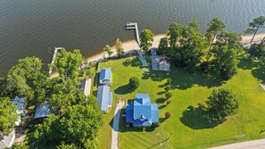 An aerial view of a residential area with houses, a dock, and a beach.