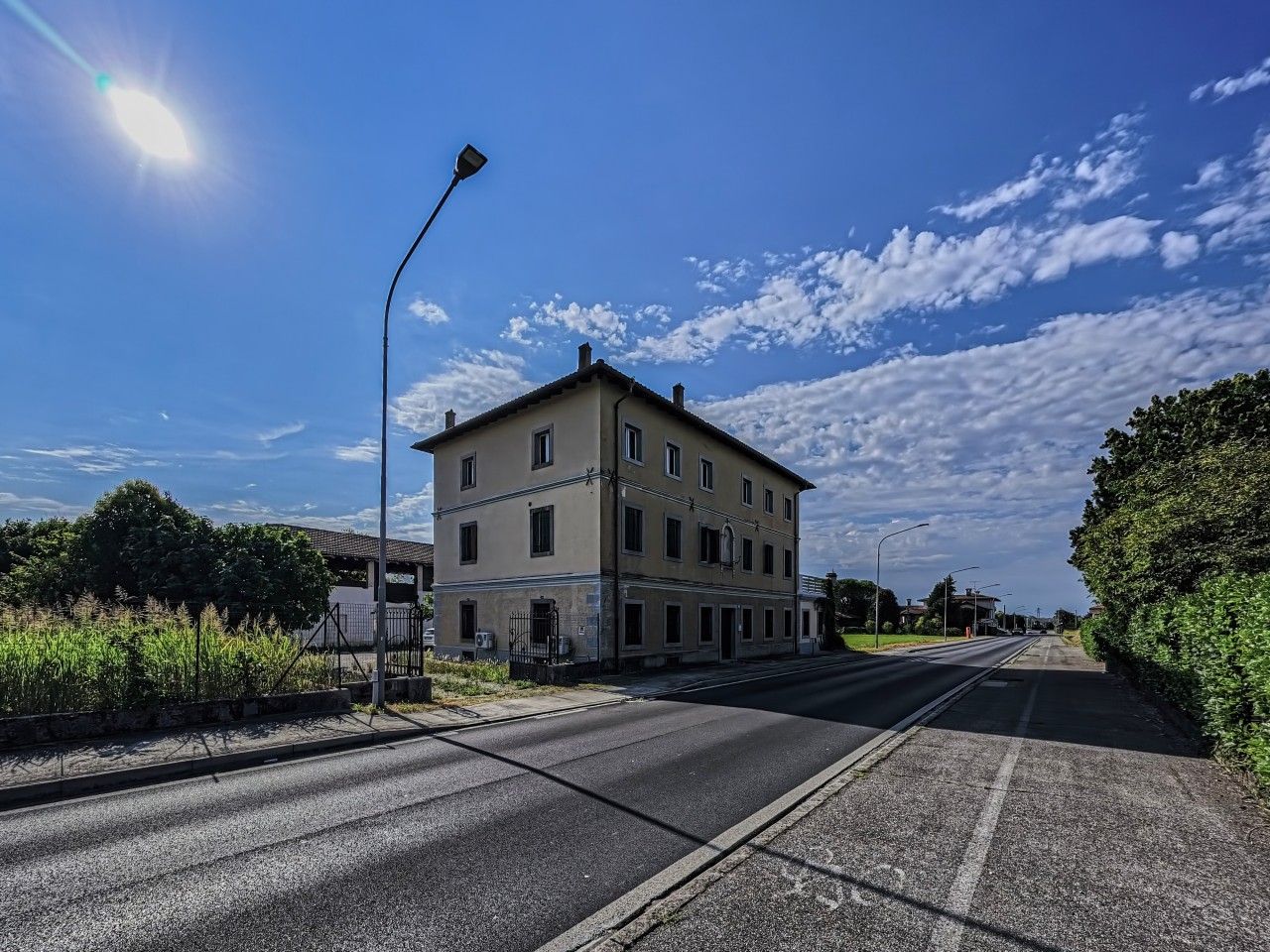 Ein zweistöckiges Gebäude mit flachem Dach, einem Eingang und einem sichtbaren Parkplatz.