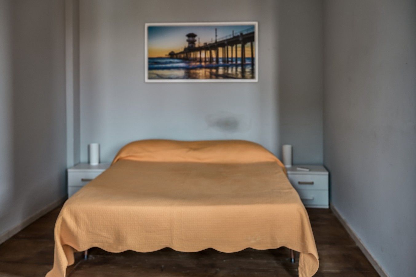 Ein Schlafzimmer mit einem Bett, Nachttischen und einem Wandbild.