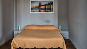 Ein Schlafzimmer mit einem Bett, Nachttischen und einem Wandbild.