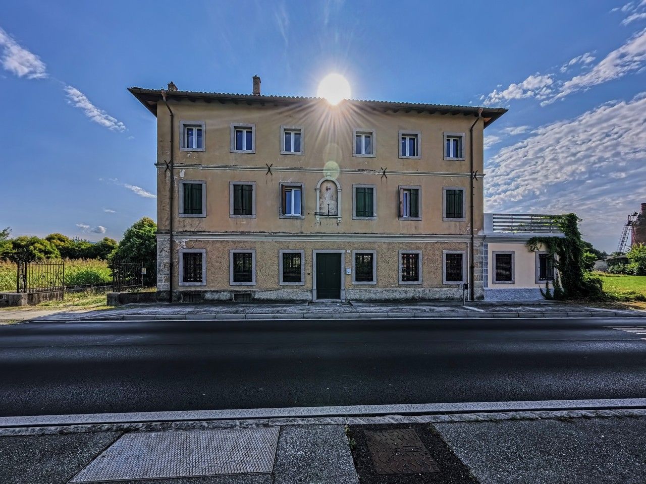 Un bâtiment à deux étages, doté d’une entrée centrale, de nombreuses fenêtres et surplombant un ciel dégagé.