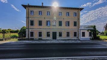 Un bâtiment à deux étages, doté d’une entrée centrale, de nombreuses fenêtres et surplombant un ciel dégagé.