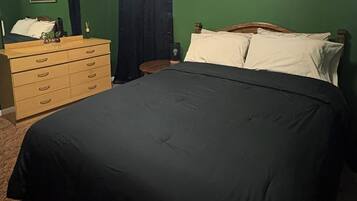 Un dormitorio con cama, cómoda y un cuadro en la pared.