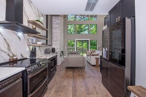 Eine moderne Küche mit Einbauherd, Backofen und Kühlschrank aus Edelstahl.