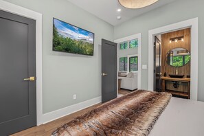 A bedroom with a large fur rug, a TV, and a wooden cabinet with a mirror. - Experience the perfect Pigeon Forge getaway at The Suite Life, a thoughtfully de (Pigeon forge)