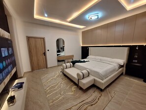 A modern bedroom with a large bed, built-in storage, a mirror, and a wall-mounted TV. - Lovely 3-bedroom house with 24/7 power supply, security, gym and pool in Lekki (Lekki)