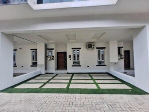 A modern building with a covered entrance, a paved courtyard, and a door with a window. - Lovely 3-bedroom house with 24/7 power supply, security, gym and pool in Lekki (Lekki)