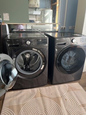 Eine Waschmaschine und ein Trockner mit Frontöffnung stehen nebeneinander in einem Hauswirtschaftsraum.