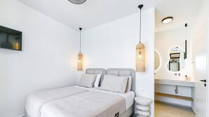 Un dormitorio moderno con cama, lámparas de noche, espejo y tocador de baño.