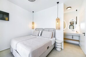 A modern bedroom with a bed, bedside lamps, a mirror, and a bathroom vanity. - Villa Amoena by Villa Plus (Ligia)
