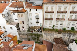A multi-story building with a mix of balconies and windows, some with decorative railings. - A Varanda do Tempo Apartment: Archaeology, History, Terrace & Wi-Fi in Central Coimbra (Coimbra)