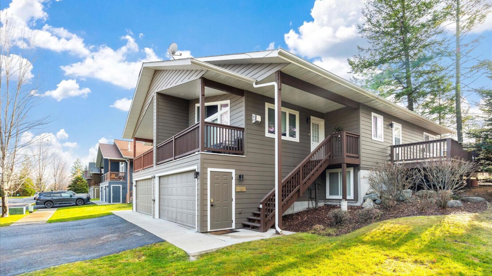 Een woonhuis met twee verdiepingen, een balkon, een garage en een trap naar de bovenverdieping.