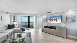 A modern living room with a sofa, coffee table, and a TV on the wall. - Top Floor Gulf View Condo at South Seas Tower IV. (Marco Island)