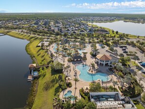 A resort with multiple swimming pools, a large central pool, and a view of a lake. - Lakeview Pool Townhome in Storey Lake Resort • Lazy River • 8 Miles to Disney (Kissimmee)