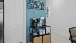 Ein Café-Bereich mit einer Kaffeemaschine, Tassen und einem Schild an der Wand.