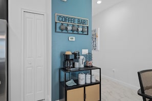 A coffee bar setup with a coffee machine, mugs, and a sign on the wall. - Lakeview Pool Townhome in Storey Lake Resort • Lazy River • 8 Miles to Disney (Kissimmee)