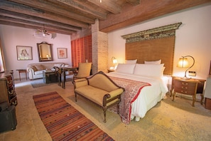 A traditional room with a bed, a sofa, a chair, a desk, and a lamp. - Casa Mejia (Cartagena de Indias)