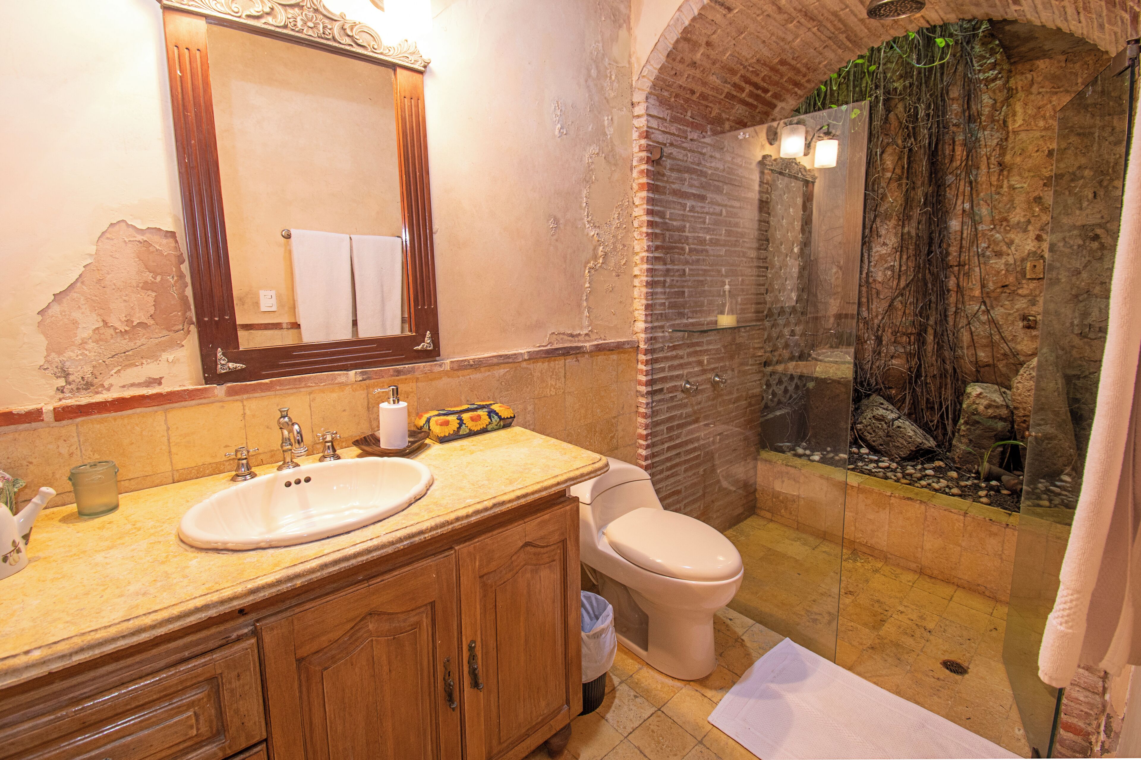 Une salle de bain comprenant un lavabo, des toilettes et un espace douche.