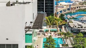 A rooftop pool area with a view of the city skyline and marina. - Downtown Studio with Pool, Gym & Movie Theater (Miami)