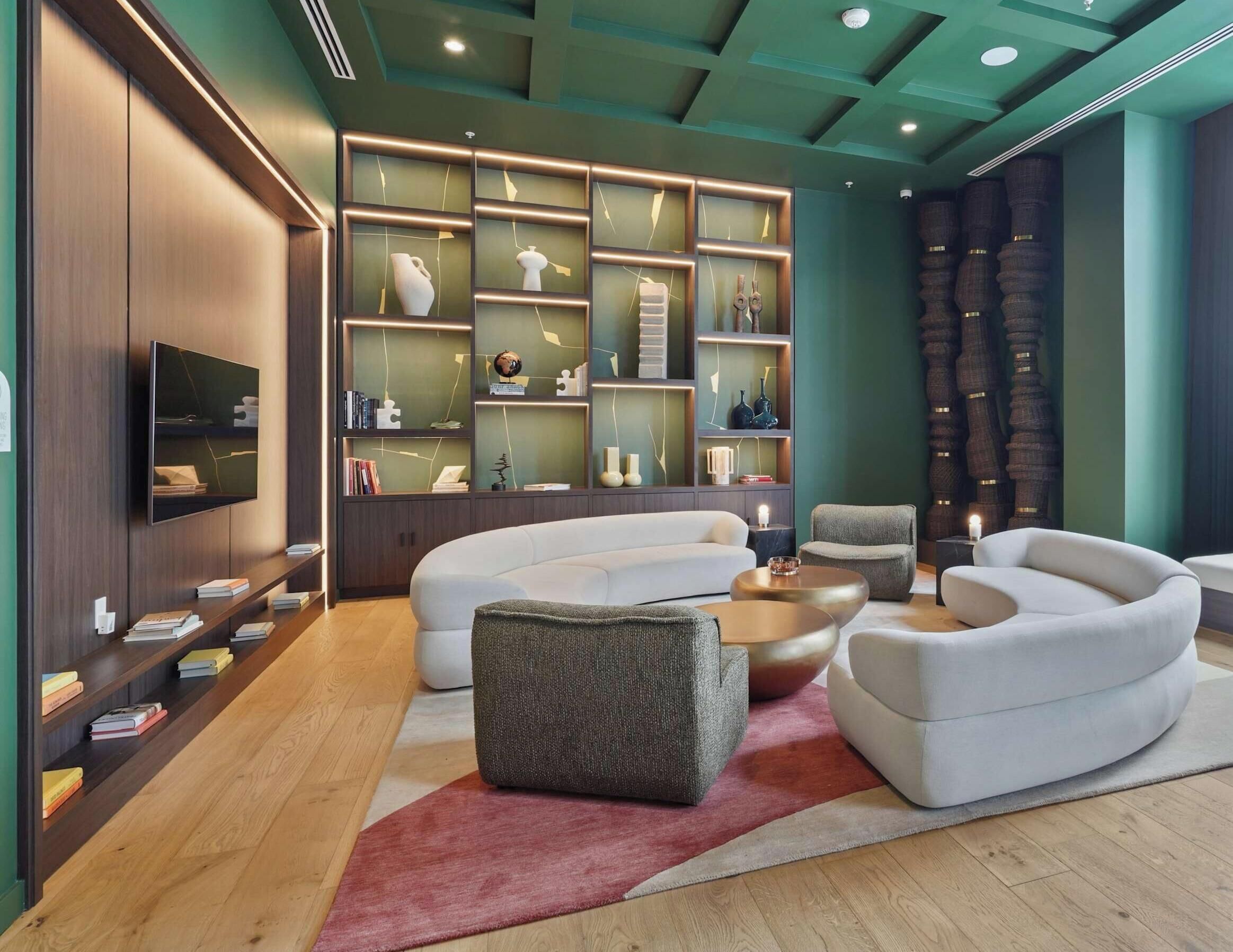 A modern living room with a sectional sofa, a coffee table, and a TV mounted on the wall.