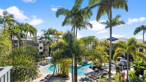 A resort with a swimming pool surrounded by palm trees and lounge chairs. - French Quarter 322 Beautiful One Bedroom Apartment (Noosa Heads)