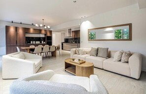 A modern living room with a sofa set, a coffee table, and a dining area with chairs and a table. - JUST A 5-MINUTE WALK FROM THE BEACH AND THE FAMOUS BOULEVARD DE LA CROISETTE (Cannes)