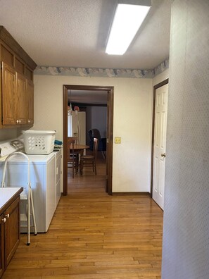 A laundry area with a washing machine, dryer, and a wooden cabinet. - Bring the whole family to this large Simpsonville home that sleeps 10 people. (Simpsonville)