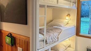 A bunk bed room with a view of a green landscape through a window. - The Banya Place - renovated cabin in Bright (Bright)