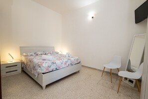 A bedroom with a bed, bedside tables, a chair, and a mirror. - Casina Le Rene – Con Ampio giardino e Piscina Privata (Poggiardo)