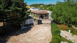 A residential property with a covered patio, a fenced garden area, and a paved driveway. - Casina Le Rene – Con Ampio giardino e Piscina Privata (Poggiardo)
