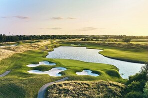 A golf course with bunkers, water hazards, and a clear sky. - L’Élégant Cocon • Terrasse • Versailles • Paris • Gare SQY (Montigny-le-Bretonneux)