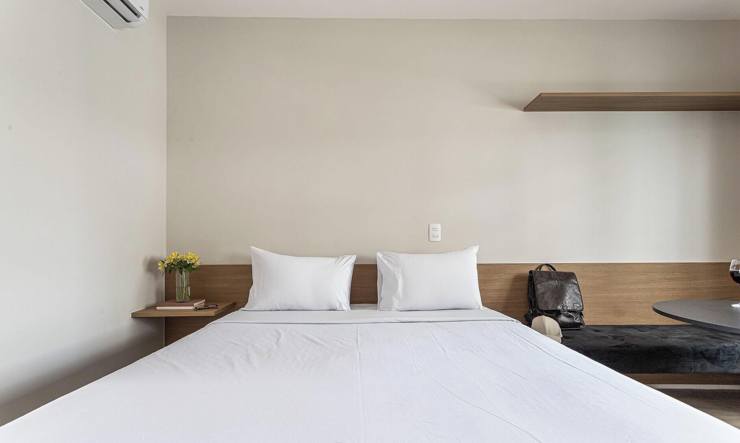 Une chambre d’hôtel avec un lit, une table de chevet et une petite table ronde.