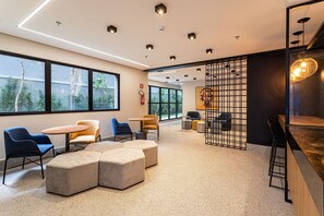 Un interior moderno con zonas de estar, un bar y ventanas amplias.