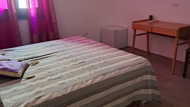Ein Schlafzimmer mit einem Bett, einem Schreibtisch und einem Sessel.