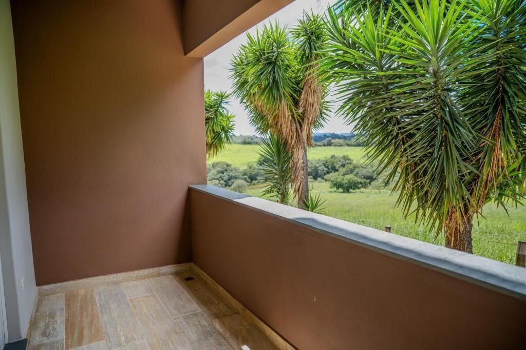 Un balcón con vistas a un paisaje verde y palmeras.